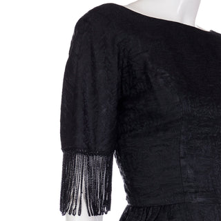 Textured black 1960s cocktail dress with beaded fringe sleeve details