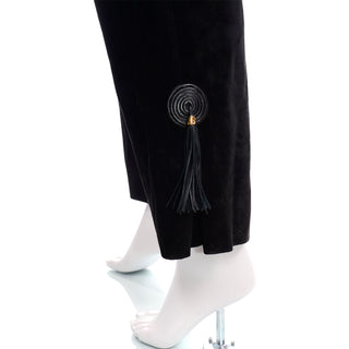 Large box pleat at ankle of black suede Gucci pants with spiral tassel detail